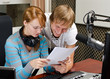 Photo: Colleagues examine broadcast list in studio Colleagues examine broadcast list in studio