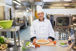 Foto: Chef standing in the kitchen with pizza Chef standing in the kitchen with pizza