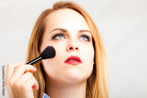 Photo: Woman applying blusher Woman applying blusher