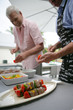 two men making skewers