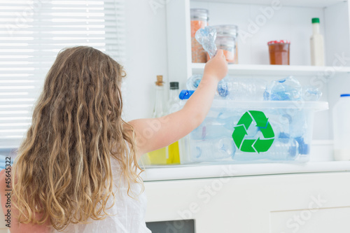 Photo: Girl putting bottle in recycling box Girl putting bottle in recycling box