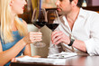 Attractive couple drinking red wine in restaurant or bar