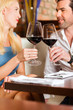 Attractive couple drinking red wine in restaurant or bar