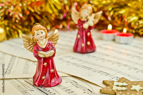 Photo: Christmas figurine of angels on a music sheet. Christmas figurine of angels on a music sheet.