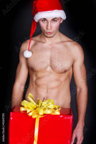 Photo: Portrait of a handsome muscular young man in Santa Claus hat Portrait of a handsome muscular young man in Santa Claus hat