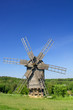 Photo: Old wind mill on a spring meadow with blue sky Old wind mill on a spring meadow with blue sky