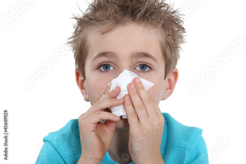 Photo: Young boy blowing his nose Young boy blowing his nose