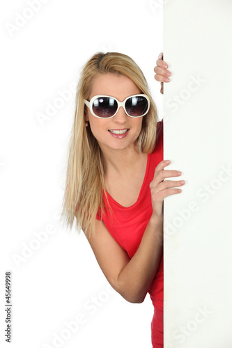 Photo: Woman in sunglasses with a blank board Woman in sunglasses with a blank board