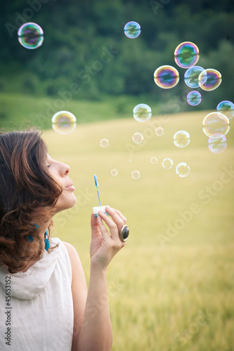 Photo: Romantic portrait of young woman with soap balloons. Romantic portrait of young woman with soap balloons.
