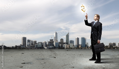 Photo: Image of a business man standing against cityscape Image of a business man standing against cityscape