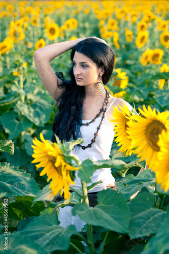 Photo: Young beautiful woman in a sunflower field with white dress. Young beautiful woman in a sunflower field with white dress.