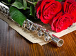 Photo: Silver flute, notes and roses. Musical background. Silver flute, notes and roses. Musical background.