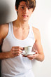 Closeup of young, handsome man thinking. Standing against wall a