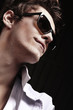Closeup of young, handsome man with glasses thinking
