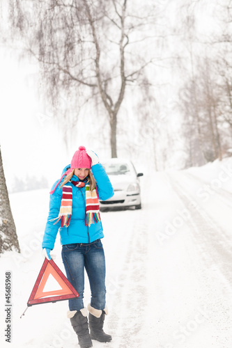 Photo: Woman with warning triangle car snow breakdown Woman with warning triangle car snow breakdown