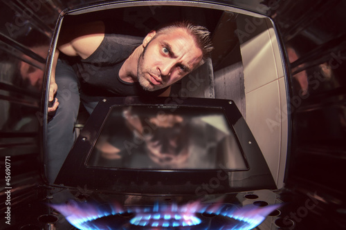 Photo: man and lit oven man and lit oven