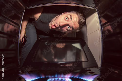 Photo: man and lit oven man and lit oven