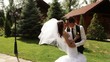 Groom and bride holding on to the hands, hurry on a path.