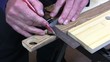 Man drawing a line and cutting a piece of wood with a saw