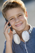 Close up portrait of boy talking on phone outdoors.