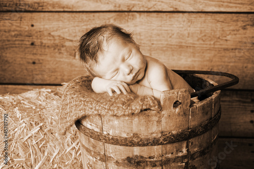 Photo: Newborn Baby Boy Sleeping in a Vintage Wooden Bucket Newborn Baby Boy Sleeping in a Vintage Wooden Bucket