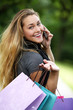 Woman with shopping bags calling by cellphone
