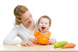 Photo: Mother with baby baby at table. Boy holding pumpkin Mother with baby baby at table. Boy holding pumpkin