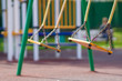 Photo: Empty chain swings on summer kids playground Empty chain swings on summer kids playground