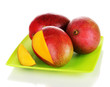 Ripe appetizing mango on green plate isolated on white