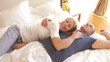Senior Couple Relaxing In Bed Together