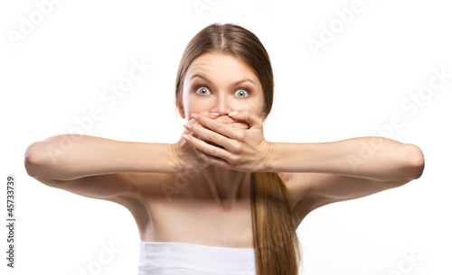 Photo: young women with wide-open eyes and closing mouth with her hand young women with wide-open eyes and closing mouth with her hand
