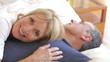 Senior Couple Relaxing In Bed Together