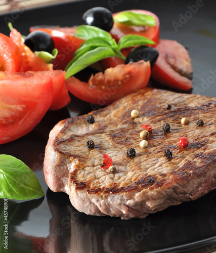 Photo: Closeup of grilled beef steak with fresh vegetables Closeup of grilled beef steak with fresh vegetables