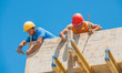Construction workers nailing cement formwork in place