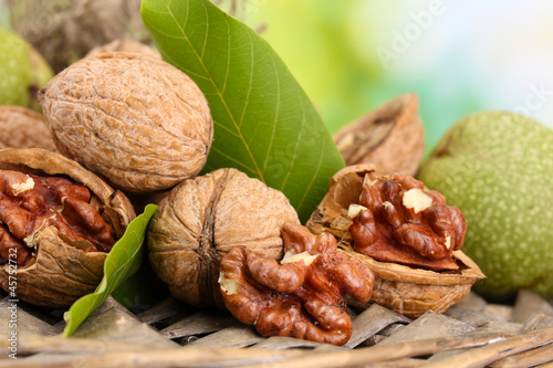 Photo: walnuts with green leaves in garden, on green background walnuts with green leaves in garden, on green background