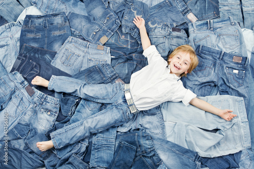 Photo: Happy child on jeans background. Denim fashion Happy child on jeans background. Denim fashion