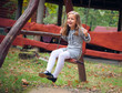 Happy Little Girl Smiling on Swing