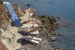 blue stairs to tranquil beach with umbrellas and chairs
