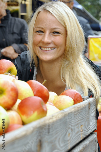 Photo: Junge Frau auf Markt mit Äpfeln Junge Frau auf Markt mit Äpfeln