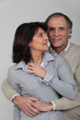 A middle age couple hugging.