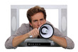 Man with megaphone coming through television