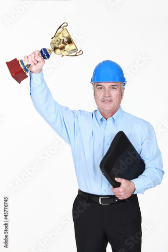 Photo: An architect holding a trophy cup. An architect holding a trophy cup.