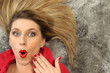 Shocked woman laying on carpet
