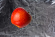 Photo: Red apple floating on a blurry silver background Red apple floating on a blurry silver background