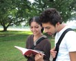 Indian / Asian college students reading a book.