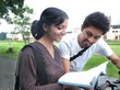 Indian / Asian college student on cycle talking to his friend.