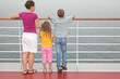 Mother with childrens stand on deck of ship look into sea