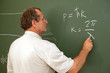 Photo: Scientist solves equation on blackboard, back Scientist solves equation on blackboard, back