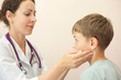 Doctor checks little boy lymph nodes, focus on boy