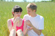Wife, husband seat on field, wife hold strawberry